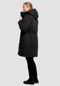 Parka negra impermeable con capucha, de longitud hasta media muslo, con cremallera en el frente, bolsillos laterales y una textura lisa y mate.