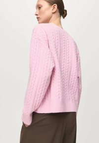 Maglione rosa a maglia rasata con un fit rilassato, maniche lunghe e orlo leggermente accorciato, realizzato in un morbido misto lana.