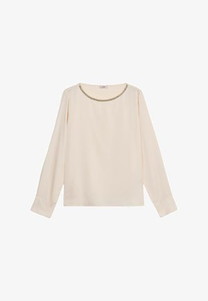 Cream long-sleeve blouse with round neckline featuring a delicate metallic chain detail. Simple, elegant design with cuffed sleeves.