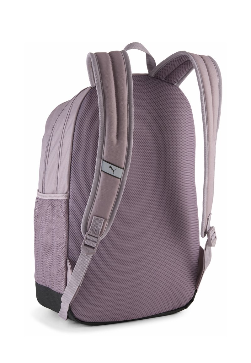 Sac à dos violet en tissu maillé rembourré, avec des bretelles réglables, une poche latérale et un fond noir. Détail du logo sur la sangle.