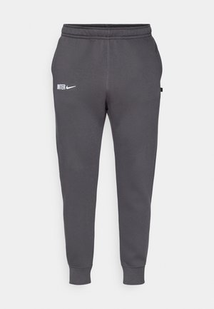 Grijze Nike joggingsbroek met een slim fit, voorzien van een wit "INTE" logo en elastische tailleband. Glad textuur met ribgebreide boorden.
