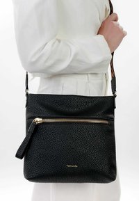 Borsa a mano nera in pelle con finitura texturizzata, dotata di una cerniera dorata, manico per il polso e tracolla regolabile con motivo.