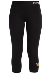 Czarne legginsy Nike z pasem o średnim stanie, z złotym logo na lewej nogawce. Wykonane z elastycznego, gładkiego materiału. Styl capri.