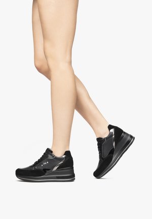 Sneakers neri che presentano una combinazione di camoscio e pelle verniciata, suola alta a zeppa, design con lacci e dettagli metallici.