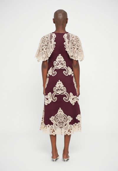 Vestido bordô com delicados detalhes em renda bege; apresenta mangas curtas em renda e intrincados padrões de renda ao longo da barra e do corpete.