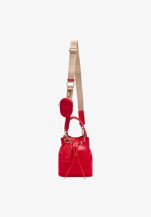 Bolso tipo cubo de cuero rojo con cierre de cordón, correa de hombro ajustable beige y pequeño bolso ovalado adjunto.