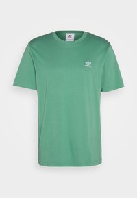 Grön bomullst-shirt med kort ärm, rund halsringning och subtil vit adidas-logga på vänster bröst. Slät textur och klassisk passform.