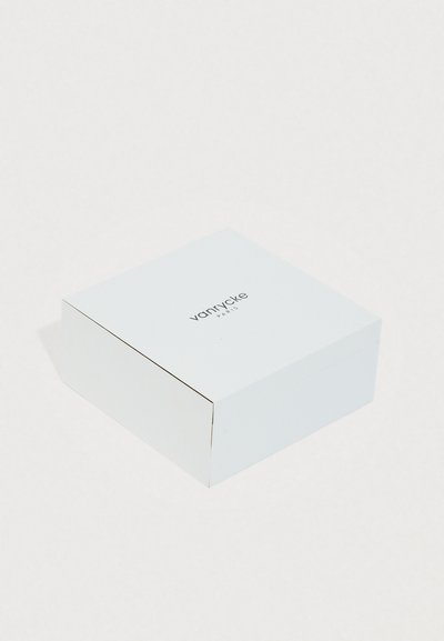 Caja cuadrada blanca con un acabado suave, con "vanrycke PARIS" impreso en la parte superior en una fuente negra y simple.