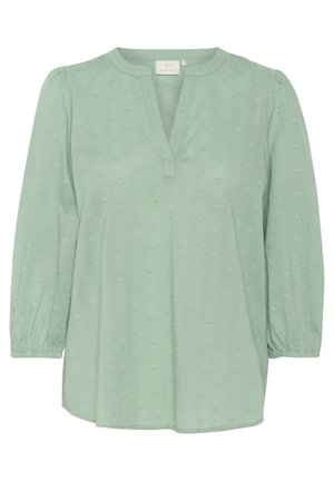 Mint zelena bluza z V-izrezom, subtilnim reliefnim vzorcem srca in 3/4 naborki. Gladka tkanina z elastičnimi manšetami in sproščenim krojem.