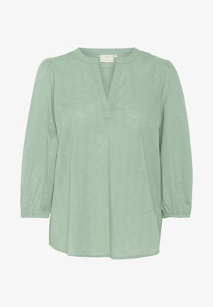 Mint green blouse with a V-neck, subtle raised heart pattern, and 3/4 puff sleeves. Smooth fabric with elastic cuffs and relaxed fit.