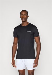 Juodas apvalaus kaklo T-shirt, pagamintas iš lengvos medžiagos, su baltu "BJÖRN BORG" logotipu ant kairiojo krūtinės. Trumpomis rankovėmis, lygaus paviršiaus.