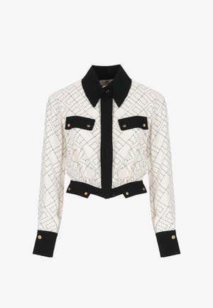 Giacca accorciata in crema e nero con un motivo a diamante, caratterizzata da un colletto nero, chiusura con bottoni, due tasche sul petto e dettagli dorati.