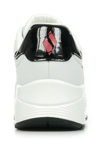 Sneaker bianco con tacco nero lucido ed emblema rosso. Presenta un'imbottitura testurizzata e una suola curva e decorata per una migliore aderenza.