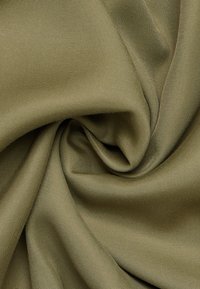 Tessuto verde oliva con una superficie liscia, caratterizzato da una tessitura fine e una superficie leggermente riflettente, disposto in un motivo a spirale.