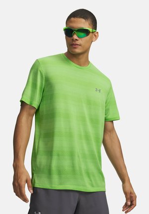 Camiseta deportiva de malla verde con cuello redondo y mangas cortas, combinada con gafas de sol con lentes tintadas en verde. Tela ligera con textura transpirable.