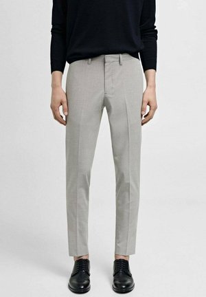 Light gray tailored trousers with a slim fit, featuring front pleats and a smooth texture, paired with black lace-up shoes.
