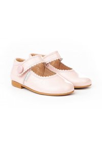 Zapatos Mary Jane de charol rosa con borde festoneado, correa ajustable y un pequeño botón redondo. Suela en color marrón claro.
