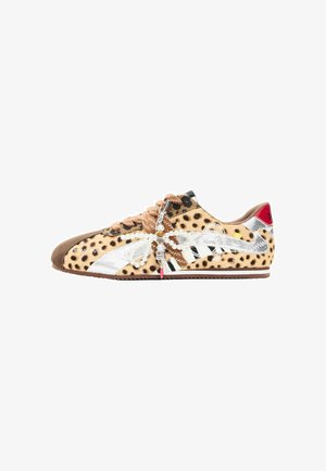 Sneaker med leopardprint, sølv- og hvid detaljer, brune snørebånd og en dekorativ vedhæng med perler og perler i form af en guldsmede.