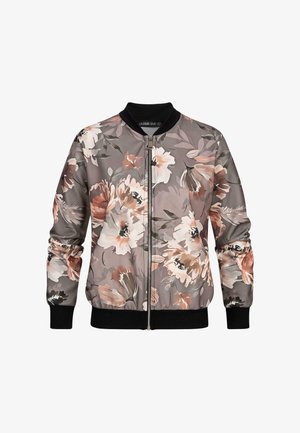 Veste bomber florale avec un fond gris, ornée de grandes fleurs roses et blanches, de poignets côtelés noirs et d'une fermeture éclair à l'avant. Texture de tissu douce.