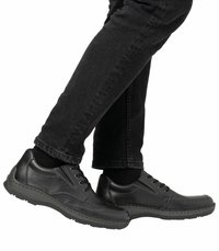 Chaussures en cuir noir avec un design à lacets, bout rond, couture contrastante et semelle en caoutchouc. Portées avec un pantalon en denim noir.