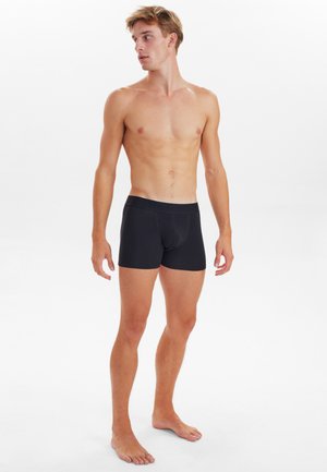 Sorte boxer shorts lavet af blødt, strækbart stof med en smal talje. Designet er tætsiddende og fremhæver benformen.