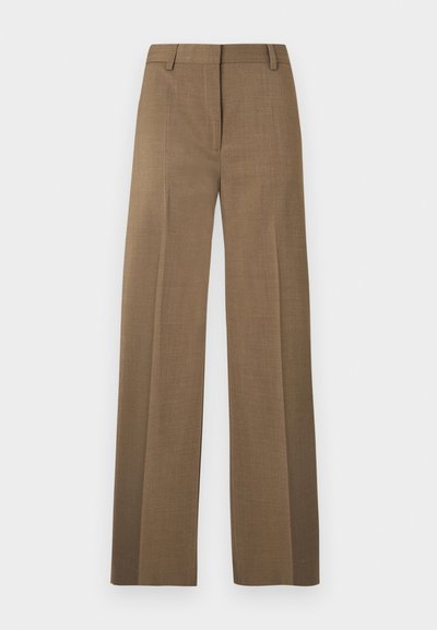 Καφέ παντελόνι με ίσια γραμμή, ζωνάκια και πρέσσα μπροστά σε ανοιχτό γκρι φόντο.