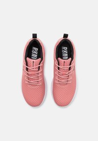 Roze mesh sport schoenen met een textuur, voorzien van zwarte veters, een gewatteerde kraag en een witte rubberen zool.