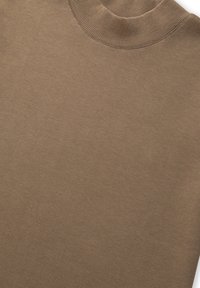 Bruine langslavige top met een geribde halslijn, gemaakt van zachte stof. Beschikt over een gladde textuur en een eenvoudig, onopgesmukt ontwerp.