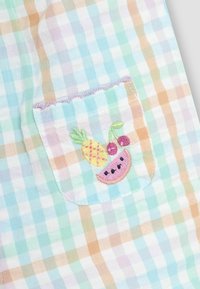 Pastelna karirana tkanina s džepom koji sadrži šarene vezene voćke: ružičasta lubenica, ananas i višnja.