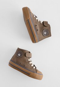 Braune High-Top-Sneaker mit Textil-Obermaterial, Gummisohlen und beigen Schnürsenkeln. Verfügt über ein rundes Patch mit einem Bären-Icon und einem Klettverschlussriemen.