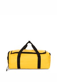 Bolsa de lona amarilla con asas y cremallera negras. Presenta una forma rectangular y una textura duradera y suave. Contiene un bolsillo lateral con cremallera.