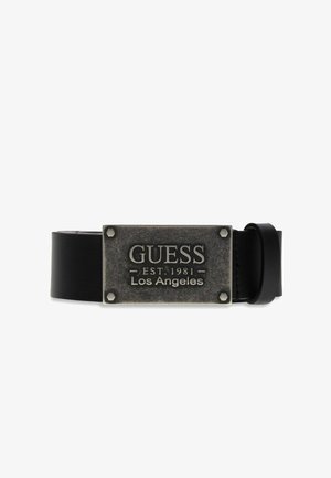 Ceinture en cuir noir avec boucle métallique rectangulaire gravée "GUESS EST. 1981 Los Angeles" et quatre détails de boulons aux coins.