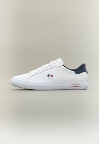 Valge toss, millel on sile nahk ülemine osa, tumesinine aksent kandadel ja punane logo silt. Lame talla ja minimaalne õmbluse detail.