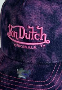 Vijolična denim kapa s šiltom, s roza vezenim logotipom "Von Dutch". Ima kontrastne šive in holografsko oznako na robu.
