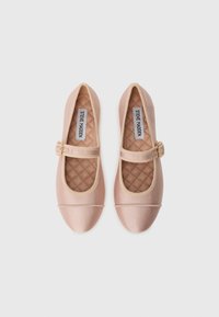 Ballerines Mary Jane rose clair avec semelles beiges matelassées, texture nervurée et bride ajustable avec une boucle dorée.