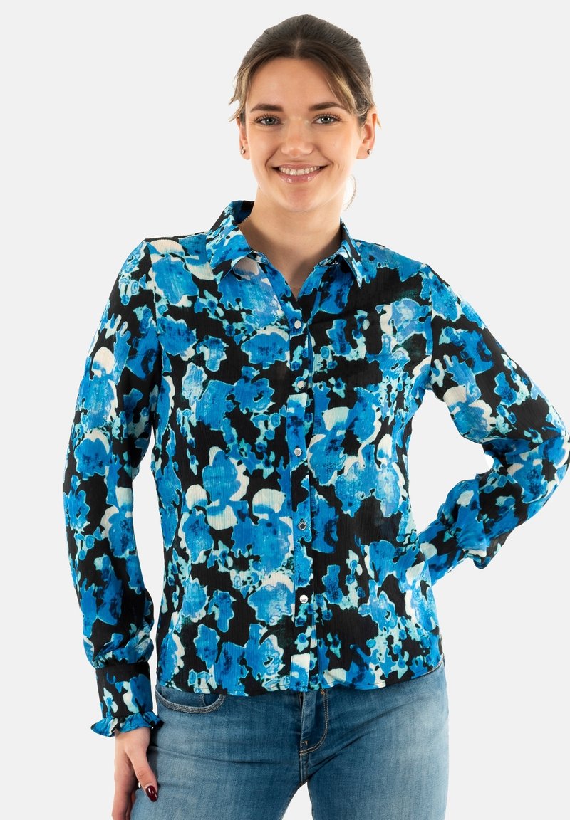 Blusa a fiori blu su uno sfondo nero, con chiusura a bottoni frontale, colletto e maniche lunghe con polsini abbottonati.