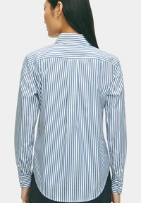 Camicia a maniche lunghe con un motivo a strisce verticali blu e bianche, realizzata in cotone, con colletto classico e polsini abbottonati.