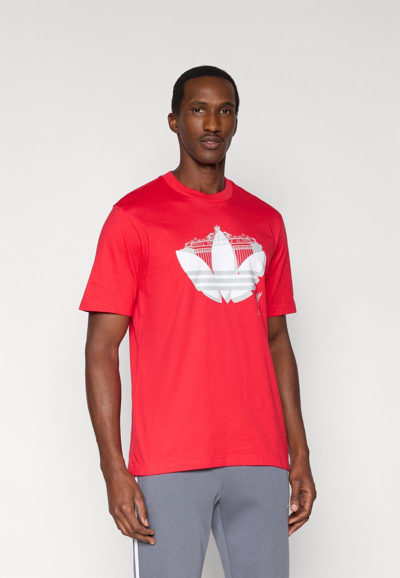 Κόκκινο βαμβακερό T-shirt με μεγάλο λευκό γραφικό σχέδιο στο μπροστινό μέρος. Με λαιμόκοψη, κοντά μανίκια και χαλαρή εφαρμογή.