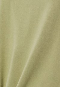 Soft olive green fabric with fine ribbed texture and draped folds.