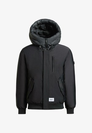 Zwarte gewatteerde jas met een gestructureerde, oversized capuchon, ritssluiting aan de voorkant en meerdere ritszakken. Gladde textuur en elastische manchetten.