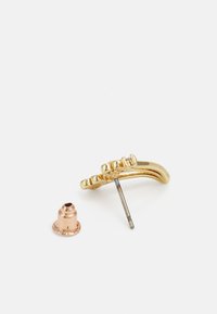 Boucles d'oreilles en métal doré avec un design courbé et des accents texturés, accompagnées d'un dos couleur cuivre et d'un tige en métal.
