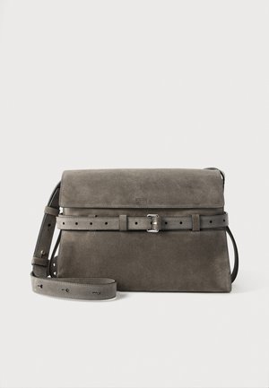 Sac bandoulière Moschino en daim gris, avec rabat, ceinture à boucle sur le devant et longue bandoulière réglable, présenté sur un fond clair uni.