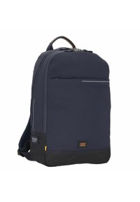 Sac à dos marine avec une forme structurée, comportant une poche frontale avec une bande réfléchissante, une poche latérale en maille et un accent en cuir à la base.