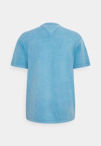 T-shirt azzurro chiaro a maniche corte realizzato in tessuto morbido, con scollatura a V e un taglio casual e rilassato. Texture liscia e cuciture minime.