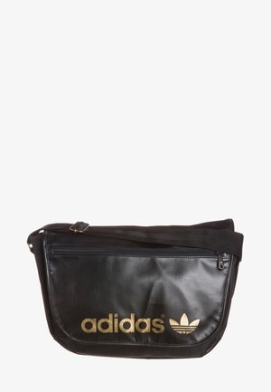 Czarna torba na ramię Adidas z złotym logo i regulowanym paskiem, wyposażona w przednią kieszeń na zamek i gładki materiał teksturowany.