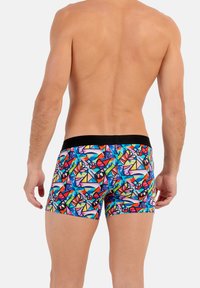 Colorful patterned boxer shorts featuring geometric designs in red, blue, black, and green with a solid black waistband.