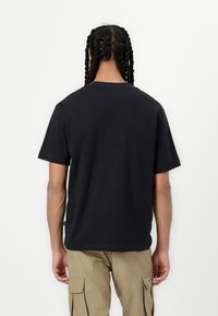 New Balance BEARDED RUNNER UNISEX - Apdrukāts T-krekls - black
