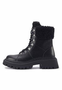 Botas negras hasta el tobillo con un puño de piel sintética, cuerpo de cuero, herrajes metálicos para el cordón y una suela de goma gruesa y texturizada.