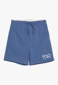 Blå bomullsshorts med elastisk midja, justerbar dragsko, sidfickor och "POLO 1992" tryckt i vitt på framsidan.