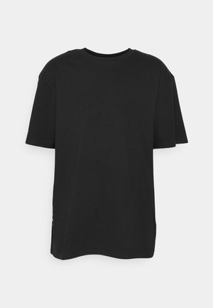 Czarny T-shirt z krótkim rękawem i okrągłym dekoltem, luźny fason na jasnym, jednolitym tle.